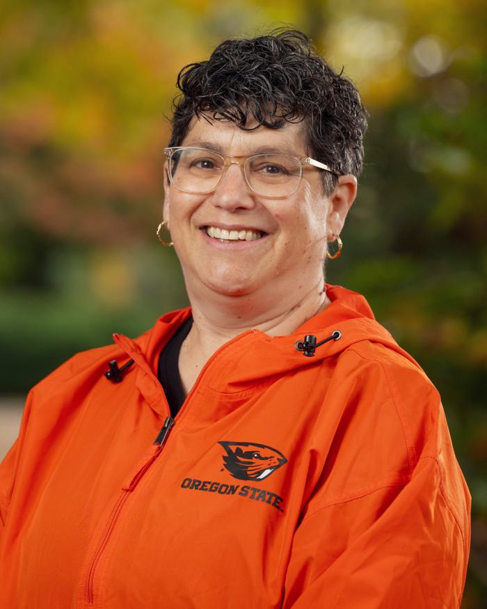 Headshot of Eleanor Feingold smiling on campus, wearing a bright beavs jacket