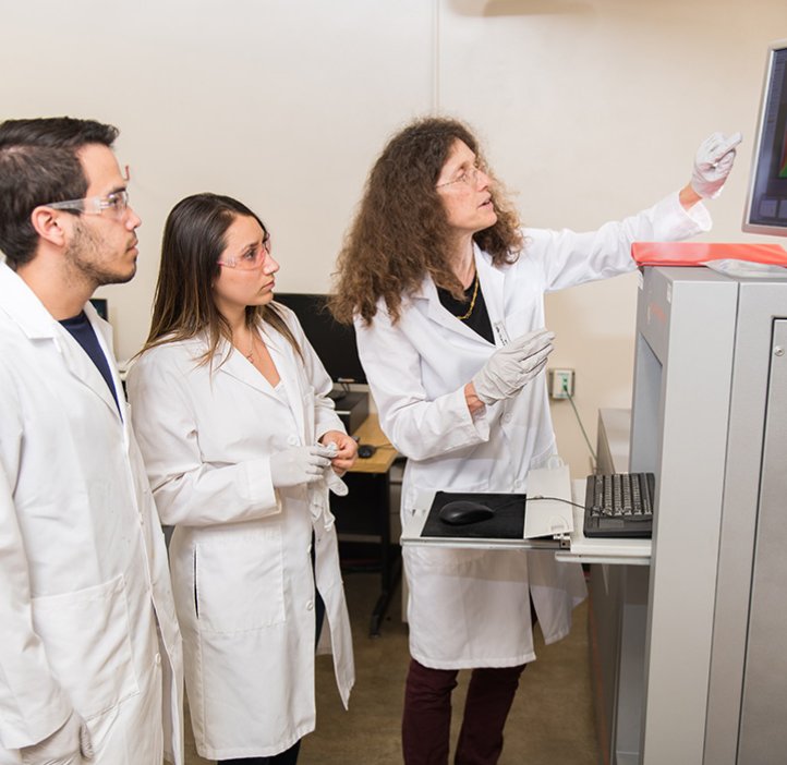 May Nyman and students checking out equipment in lab