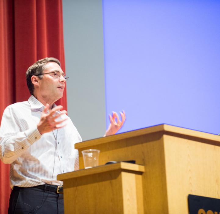 Carl Wieman speaking behind podium on stage