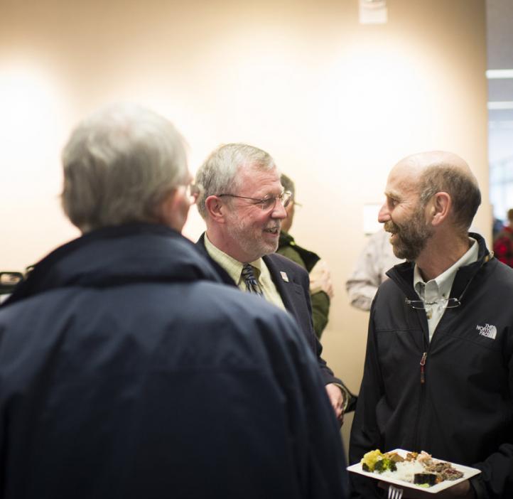 Robert Mason chatting with colleagues in lobby