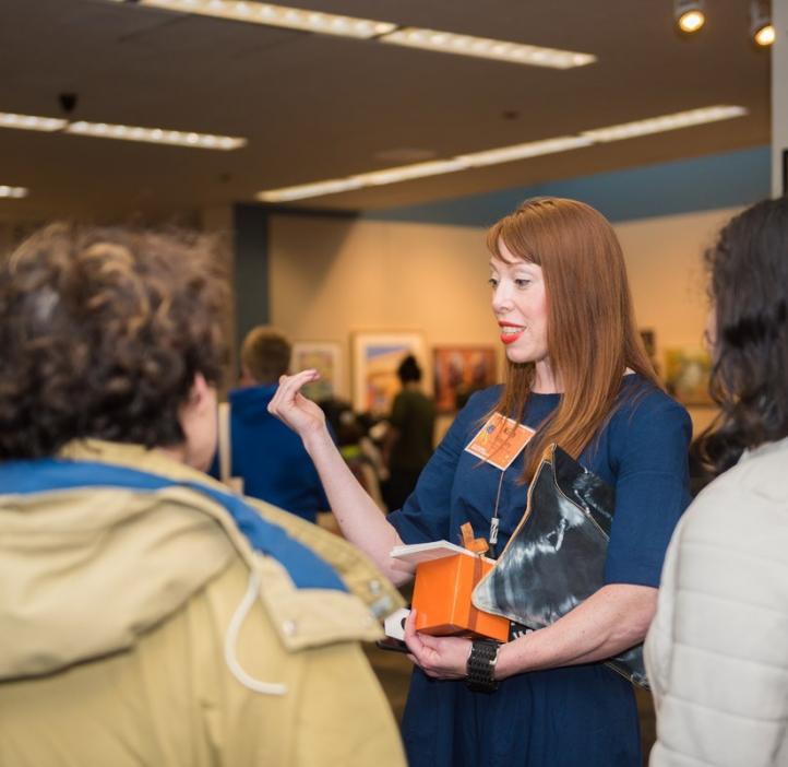 Kim Kenney speaking with colleagues in lobby