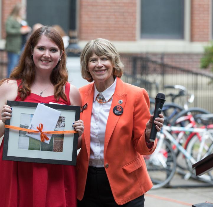 Student holding gift from faculty member
