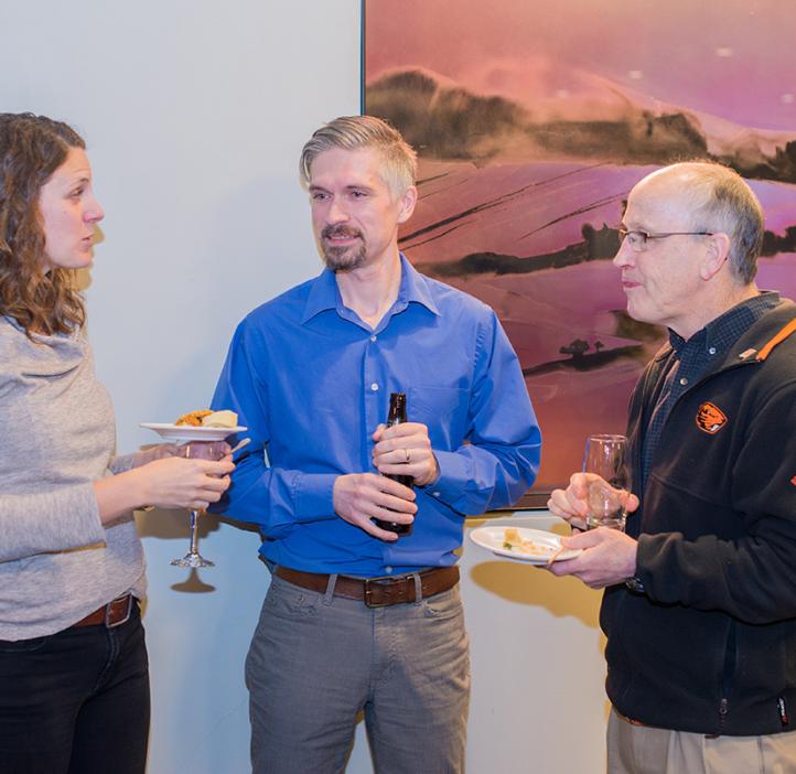Faculty chatting over drinks and food