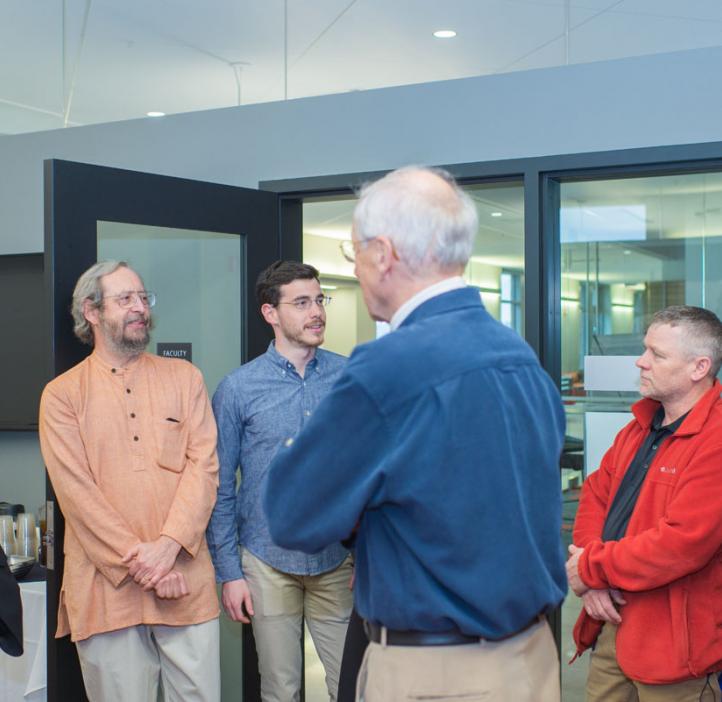 Tevian Dray and Roy Haggerty chatting with colleagues in lobby