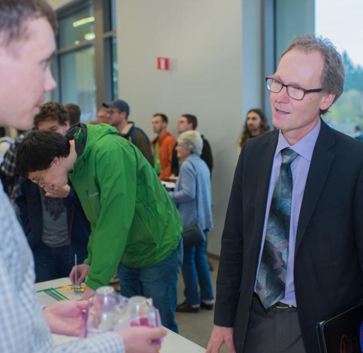 Roy Haggerty chatting with student at science club booth