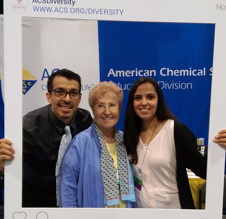 two OSU SACNAS students and elderly woman holding up instagram interface poster