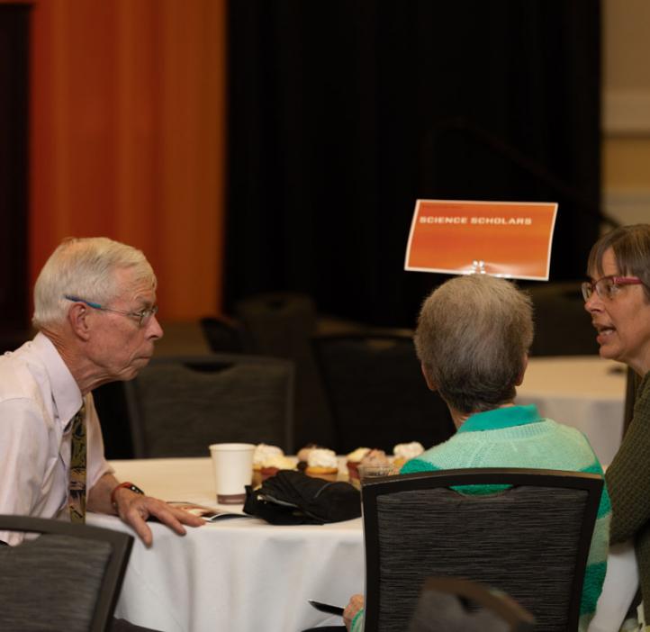 faculty chatting at table
