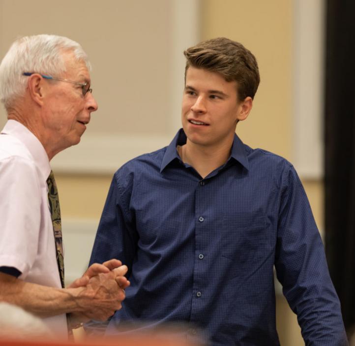 male student speaking with scholarship representative