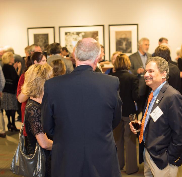 Mas Subramanian talking with colleagues in lobby