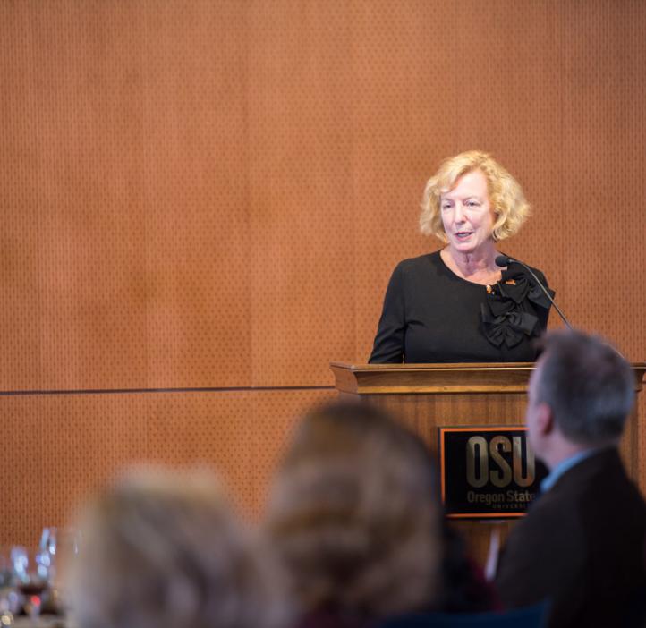 Gretchen Schuette talking on stage from podium