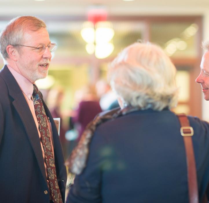 Robert Mason talking with faculty