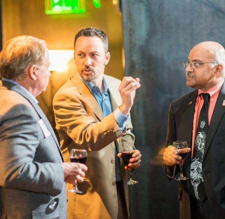 Sastry Pantula talking with male colleagues over wine