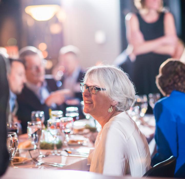 Virginia Weis talking with colleagues at table