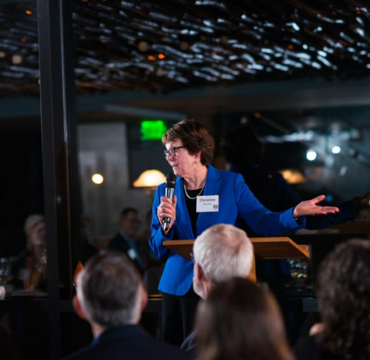 Christine Vernier speaking to audience from podium