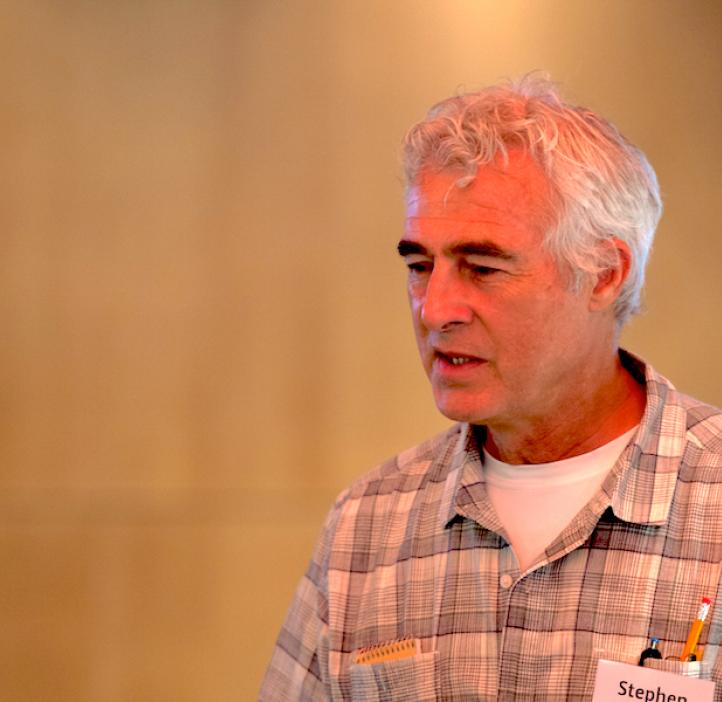Steve Giovannoni, Distinguished Professor of Microbiology, in front of beige backdrop