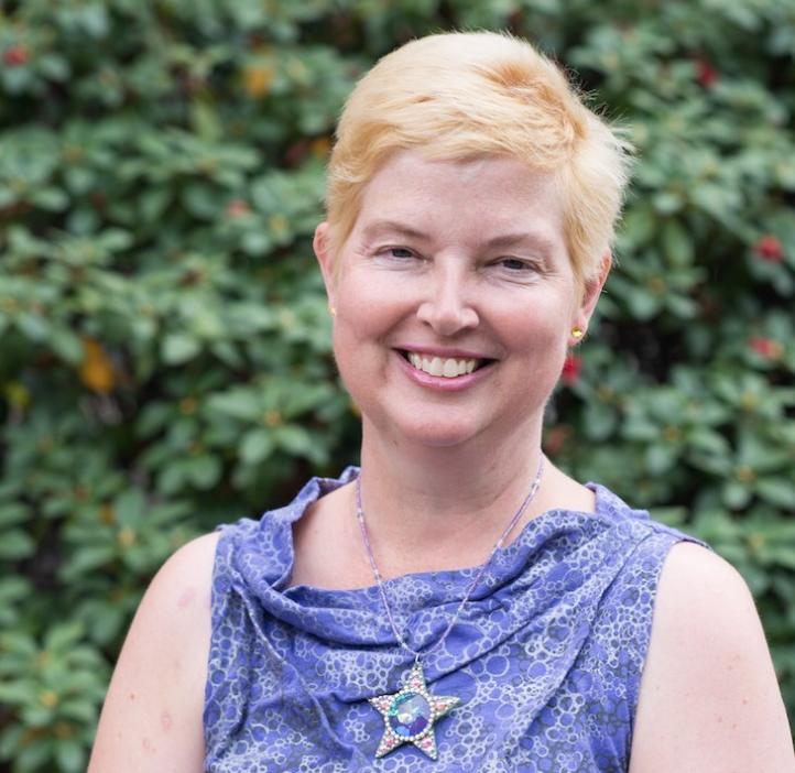 Lesley Blair standing in front of shrubbery