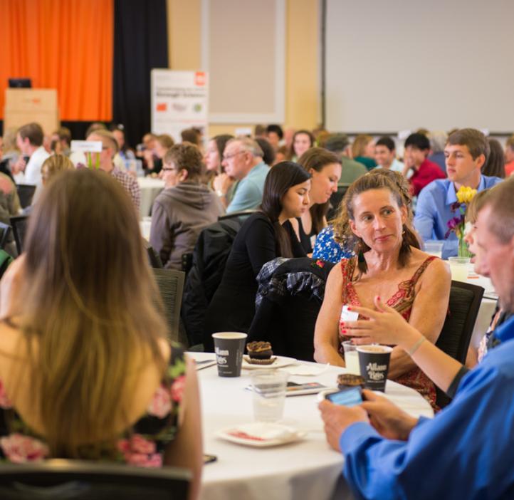 students with family and colleagues talking at table