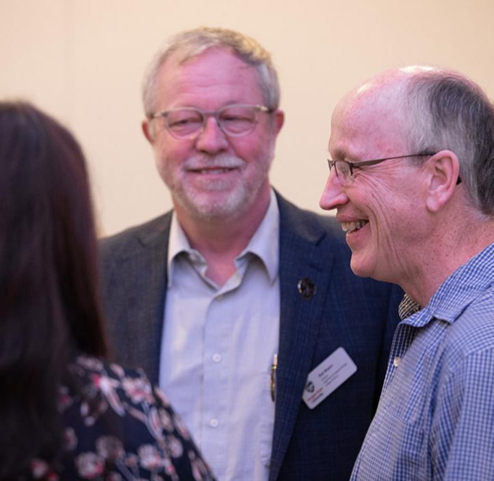 Bob Mason and Andy Karplus speaking with an event attendee
