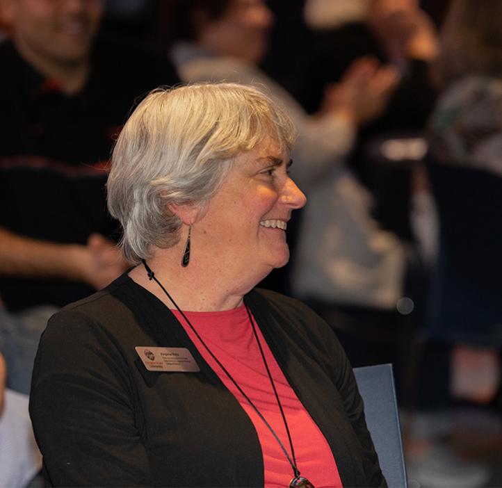 Virginia Weis laughs while sitting at a table during event