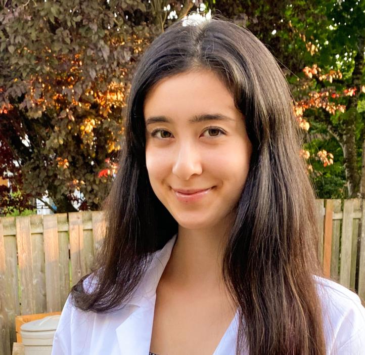 Gretchen Fujimura standing outside in a white lab coat.