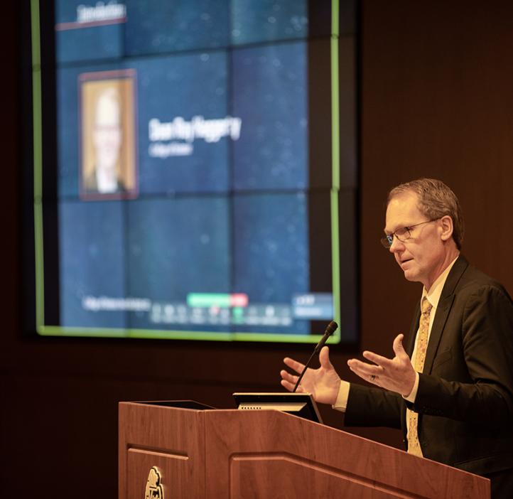 Roy speaking at a podium