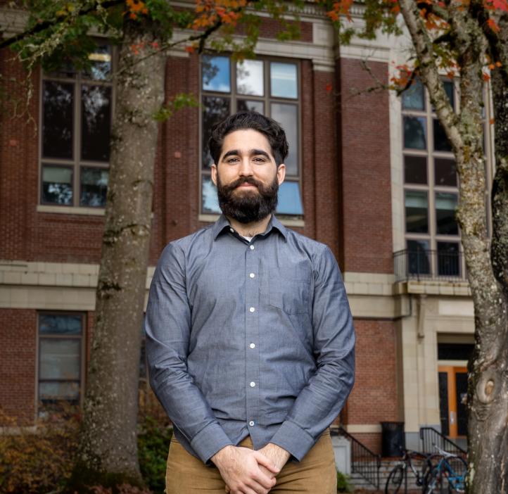 Fernando Angulo Barba stands in a blue shirt and khaki pants in front of Kidder Hall.