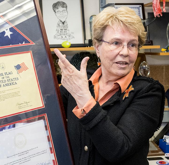 Jane Lubchenco stands in a suit referencing her framed United States flag