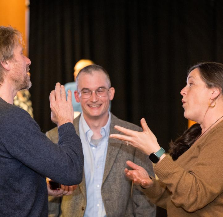 Three participants engage in an exciting conversation during the awards ceremony at Oregon State University.