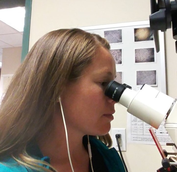 Micah Rogers analyzing samples beneath the microscope.