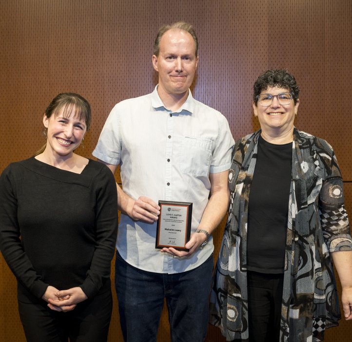 Jessica Siegel and Eleanor Feingold present an award to Malcolm Lowry. 