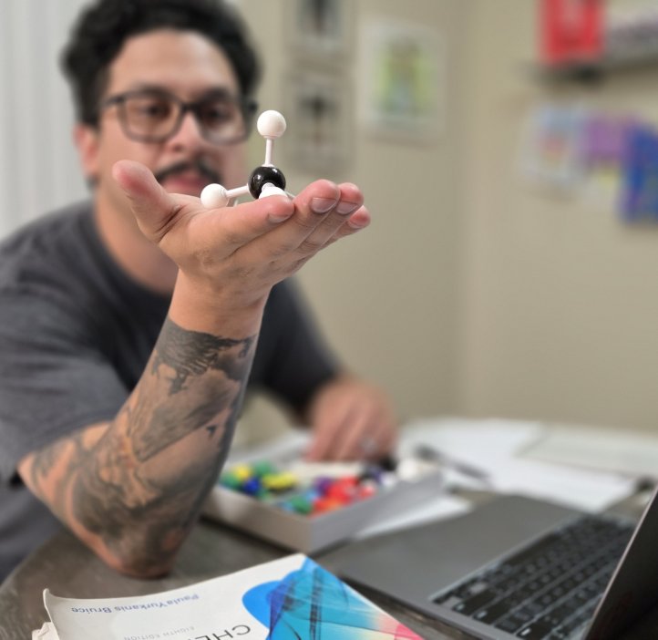 Esteban Contreras holding an atom model from a chemistry kit.