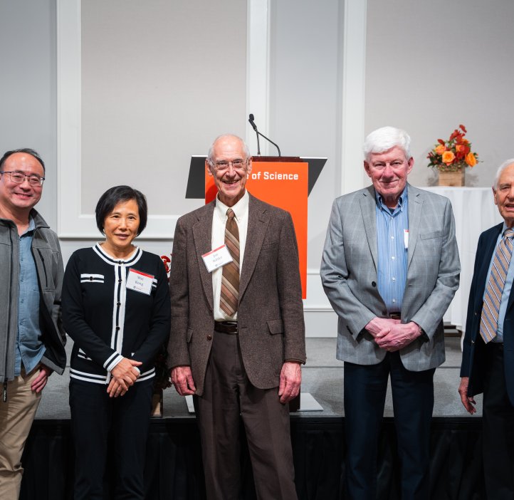 A group of five people pose for a photo.