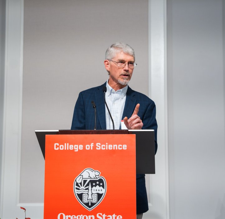 Bill Skach stands at a podium with the College of Science logo, addressing the audience during the Alumni Awards Ceremony.