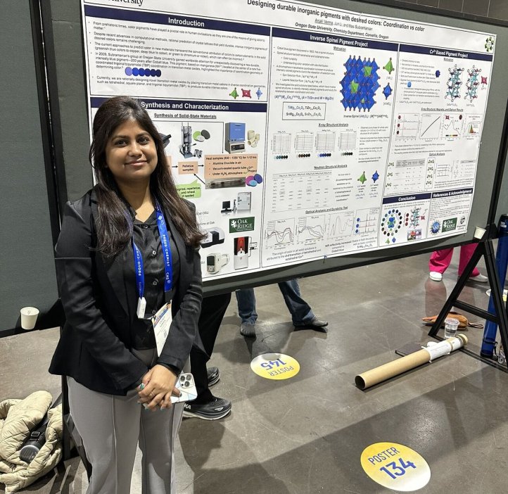 A grad student poses next to their research paper at the 2025 American Chemistry Society national conference.