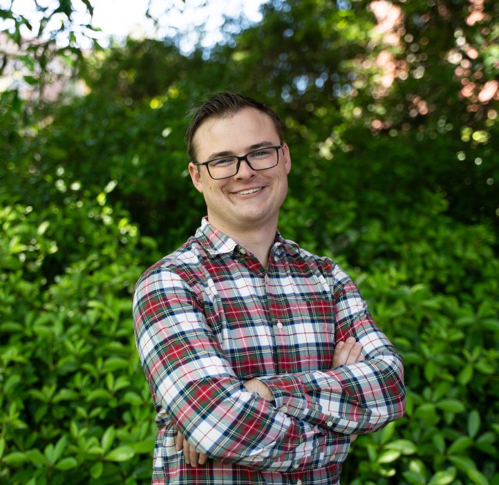 A man in a plaid shirt poses for a photo.