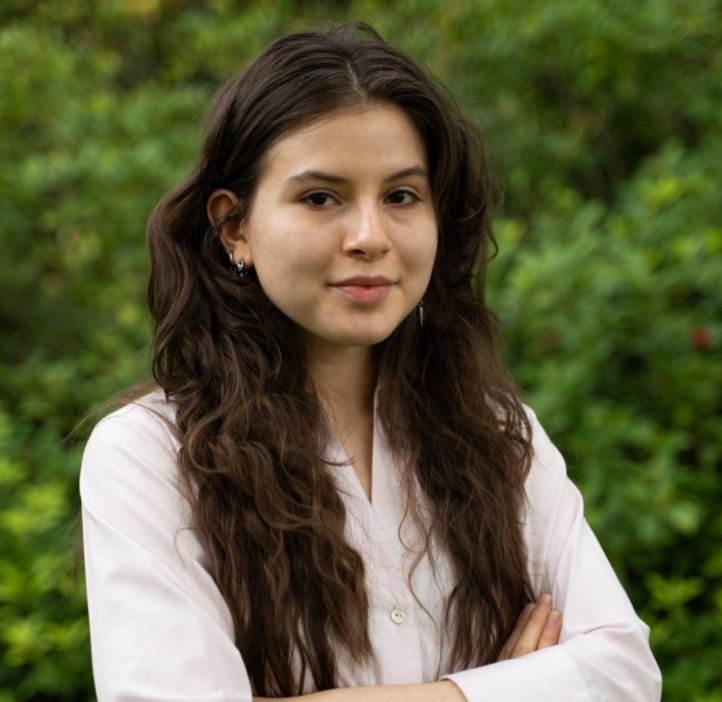 A woman in a pink shirt poses for a headshot.