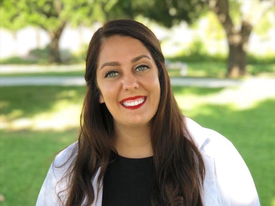 Jessica Glossop, outside in a white lab coat.