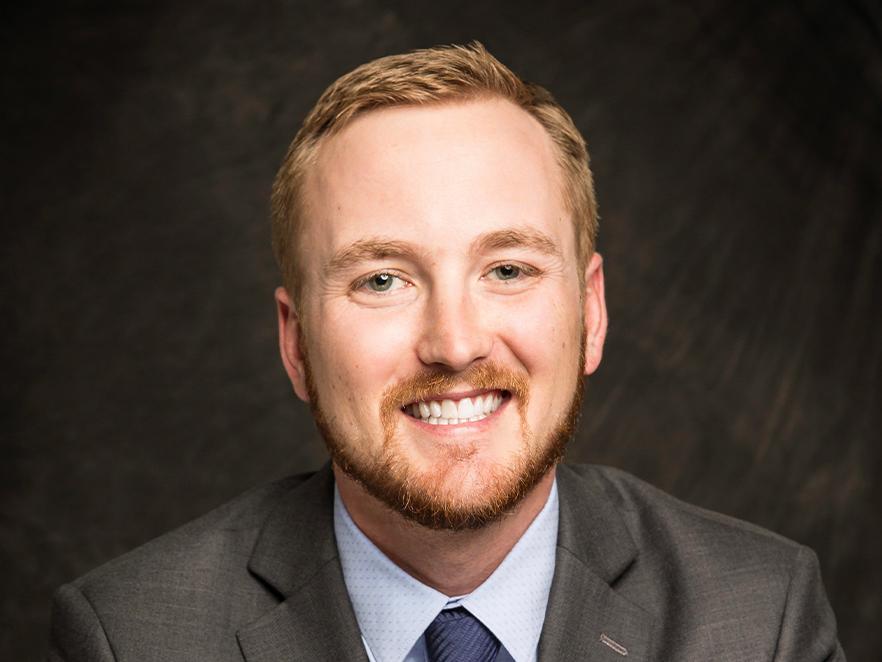Kevin Corey, a man with short blonde hair in a suit, smiling