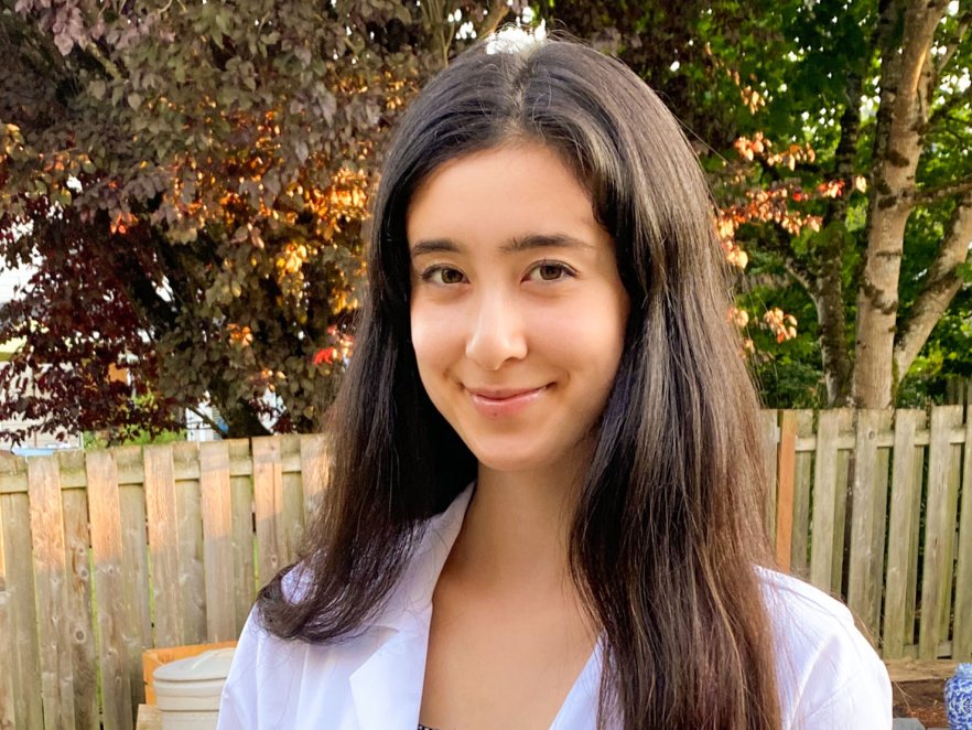 Gretchen Fujimura standing outside in a white lab coat. 
