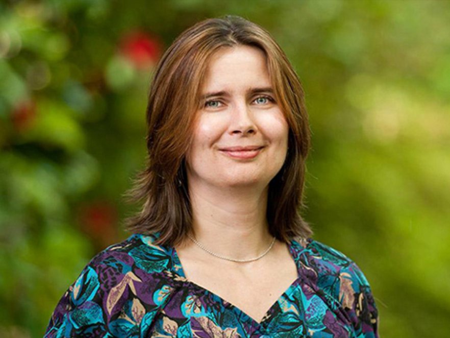 Oksana Ostroverkhova smiling on campus in spring