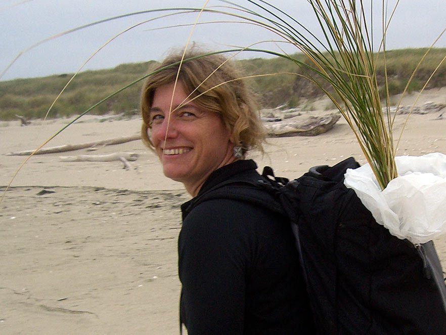 Sally Hacker carrying grass on an Oregon beach