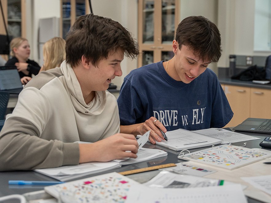 Two smiling students work together in a biology class