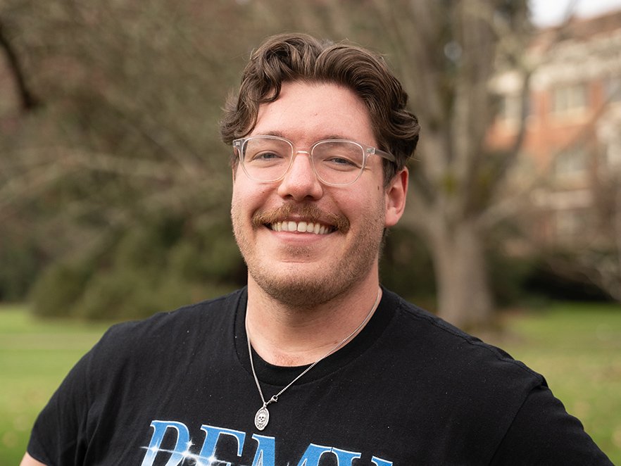 Smiling headshot of Eric Cole in a REMY band shirt