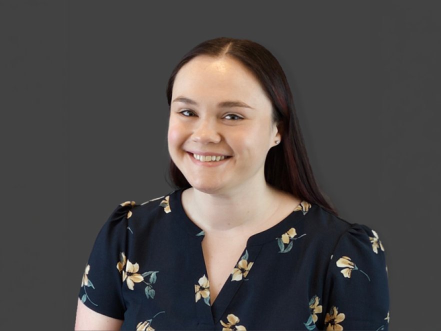 Headshot of a woman in a floral shirt smiling